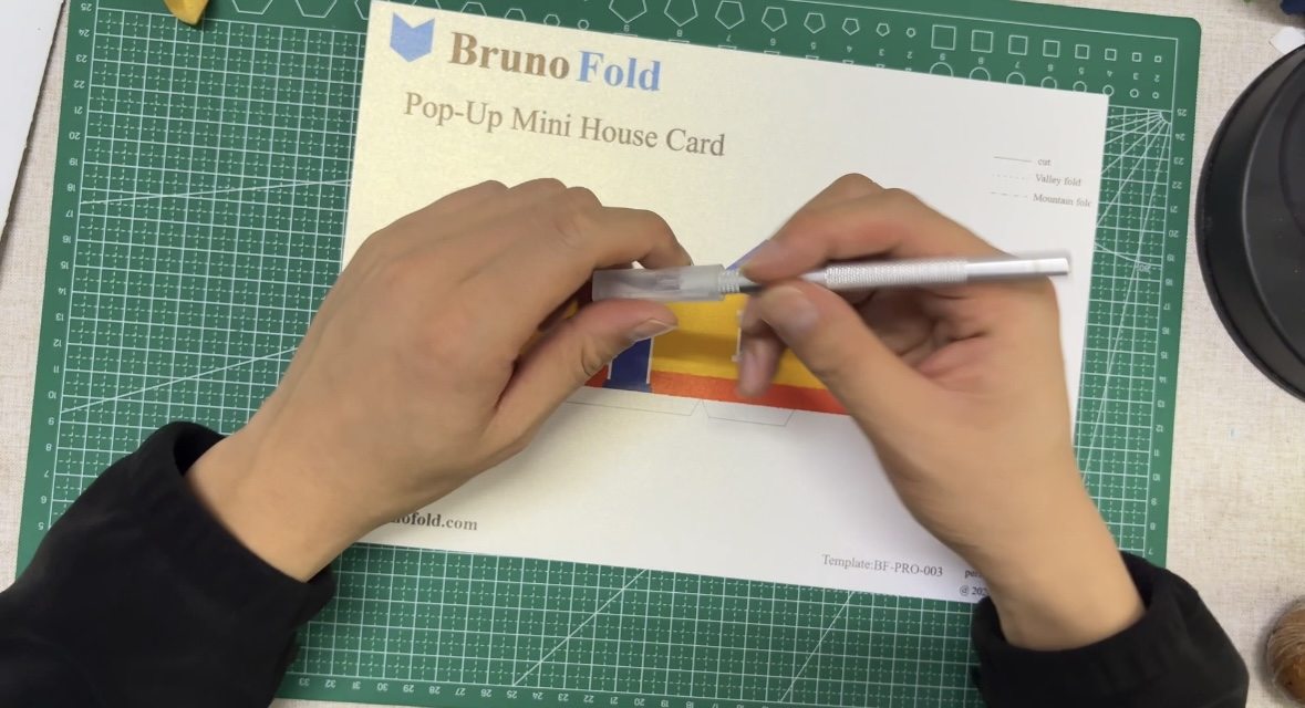 Cutting the printed pop-up house template with a craft knife