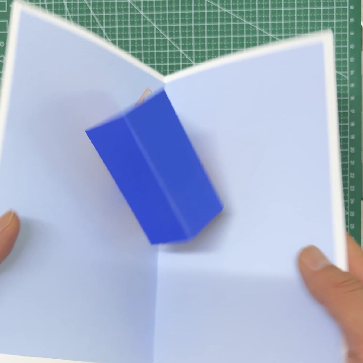 Pop-up house mechanism folding flat as the card closes
