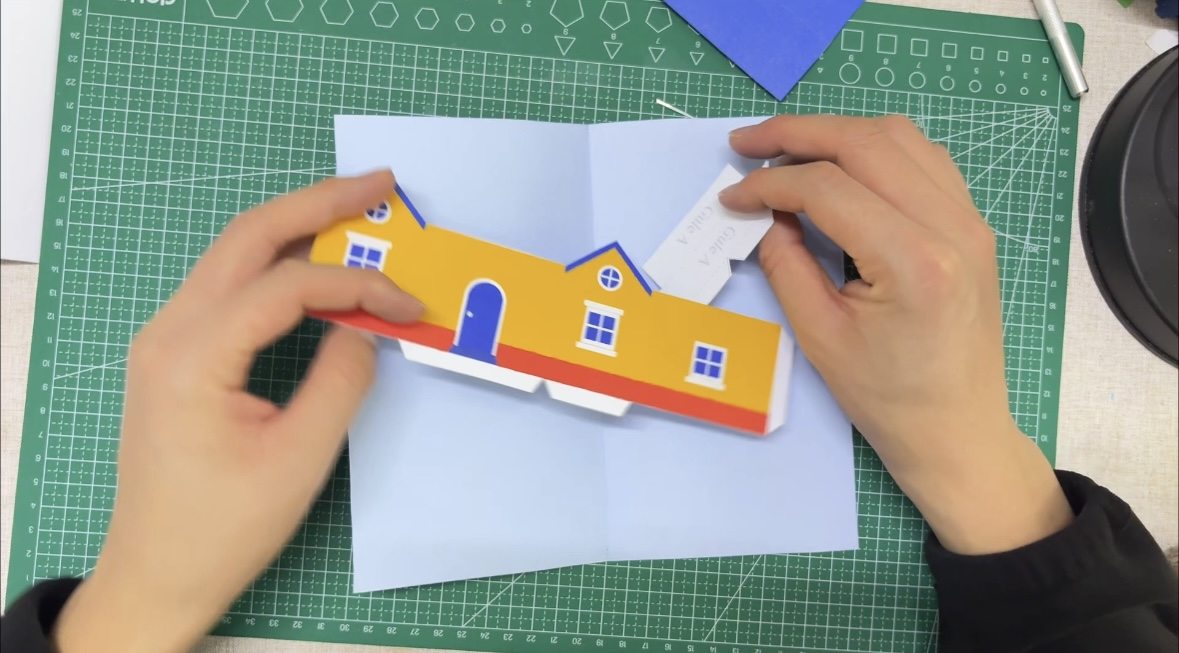 Cut pop-up house card pieces laid flat before folding